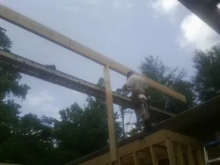 Carpenter setting a ridge beam over a new addition frame — Ice Dam Removal by Roofing Brothers in North Bridgton