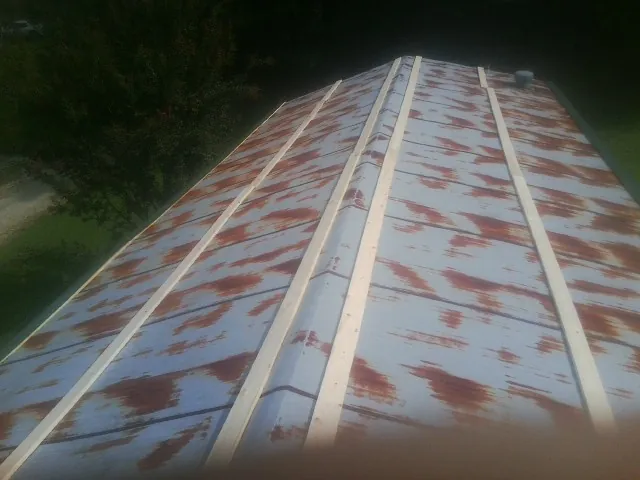 Rusted metal roof panels with new wood purlins before replacement — Storm Damage Roof Repair in North Bridgton by Roofing Brothers