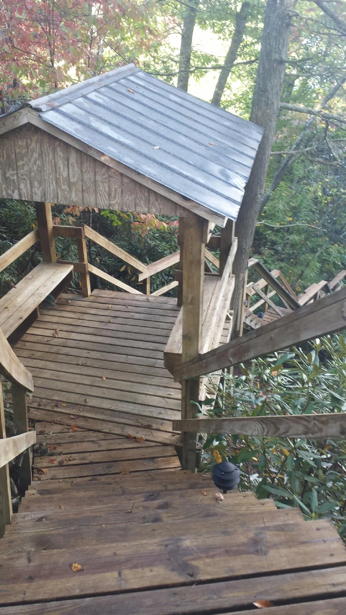 Metal roofed shelter over wooden steps on a wooded walkway — Skylight Repair & Installation work by our crew in North Bridgton